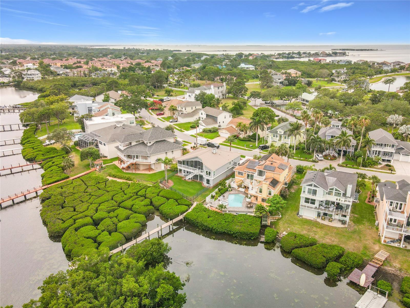 This aerial view showcases the seamless integration of this waterfront home with its lush surroundings, where vibrant mangroves and serene waters create a pristine escape from the everyday hustle