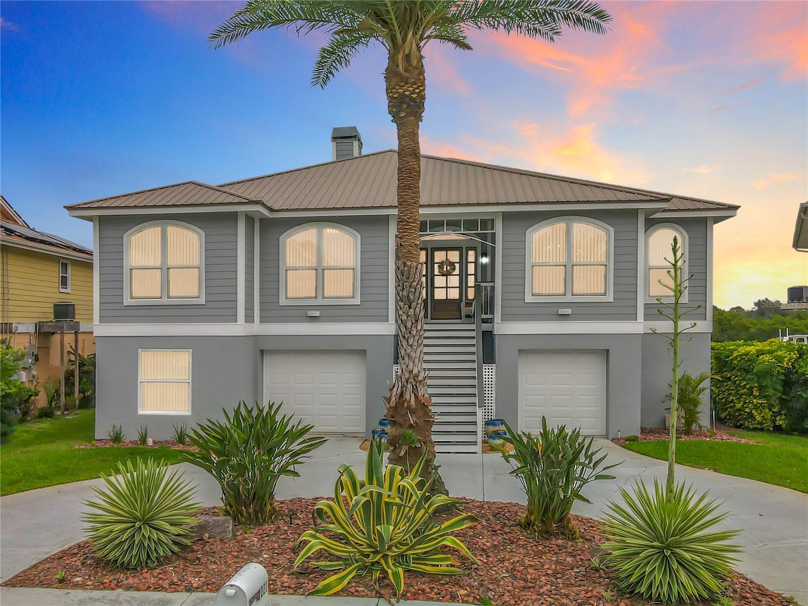 Bathed in the warm glow of twilight, the front of this beautiful home invites you to envision a new chapter of life by the water. Let the enchanting ambiance and inviting essence of waterfront living capture your heart and inspire endless memories.