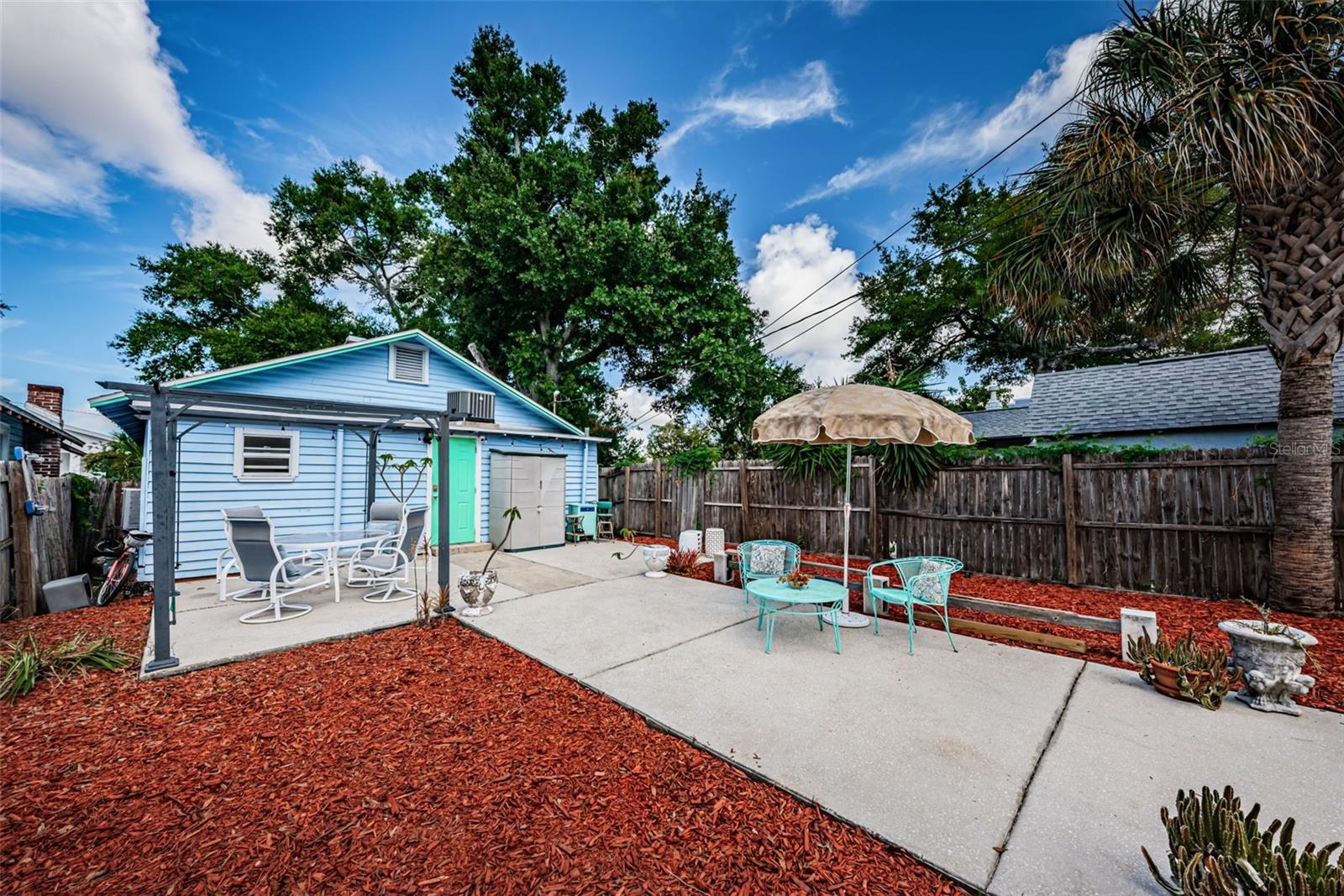 Back yard with large open patio, fully fenced with gate.