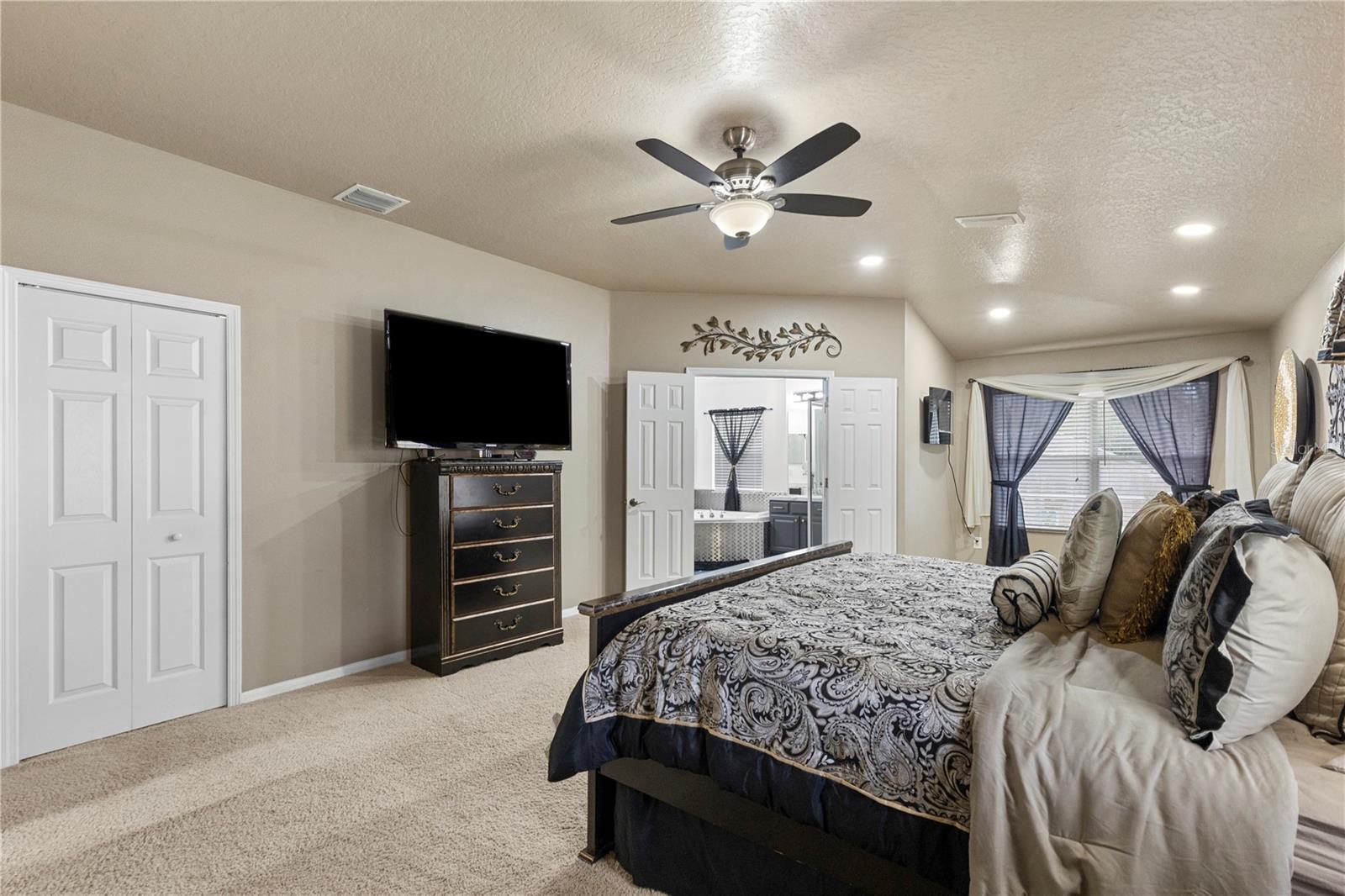 Primary Suite with sitting area, walk-in closet with closet system, and ensuite