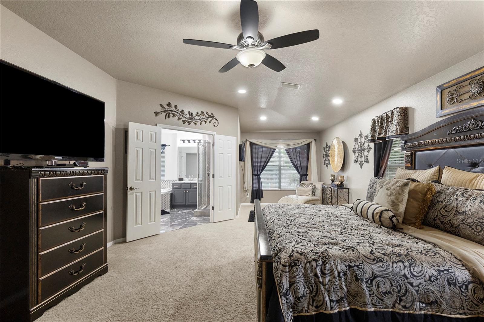 Primary Suite with sitting area, walk-in closet with closet system, and ensuite