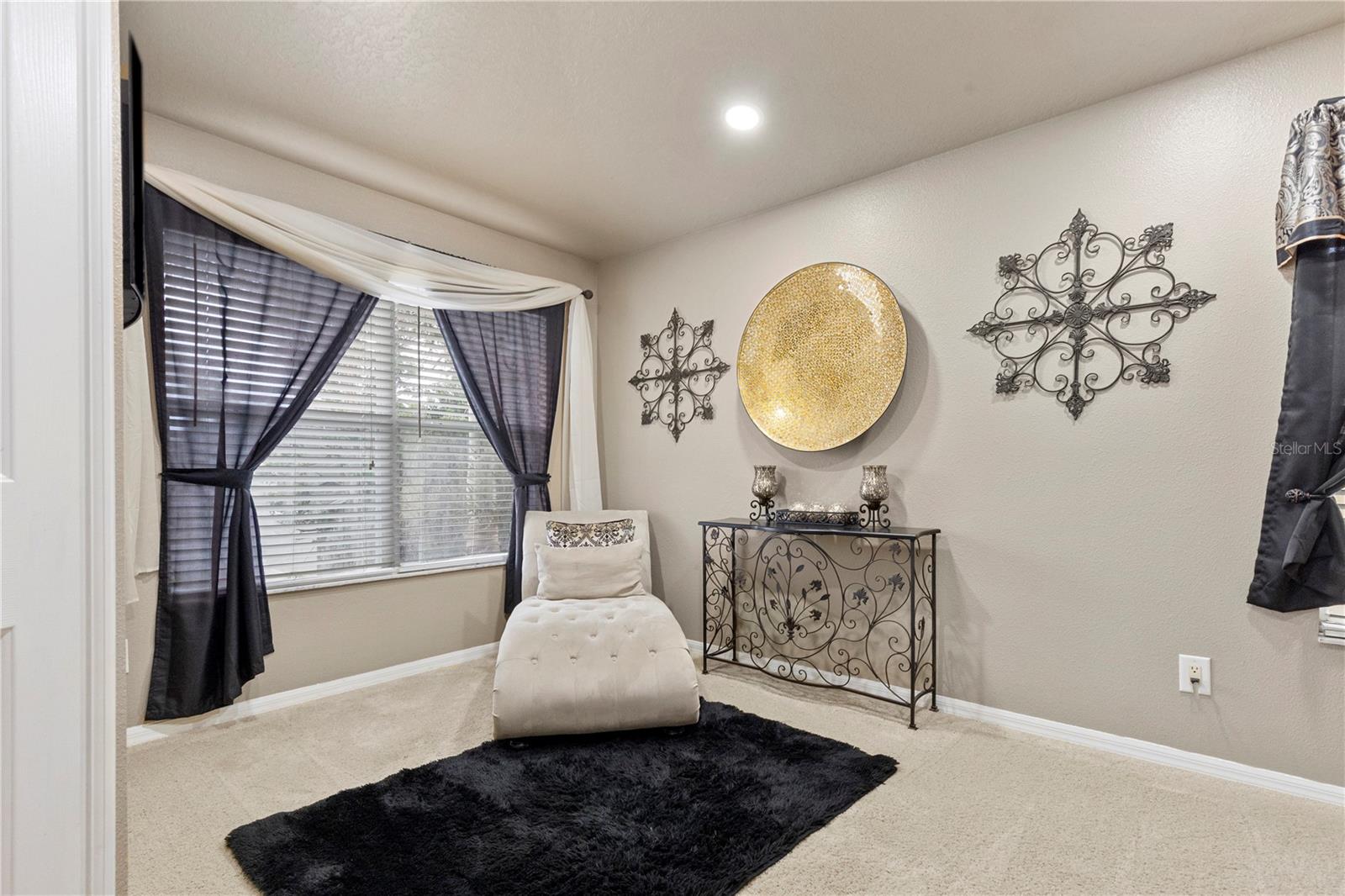 Primary Suite with sitting area, walk-in closet with closet system, and ensuite