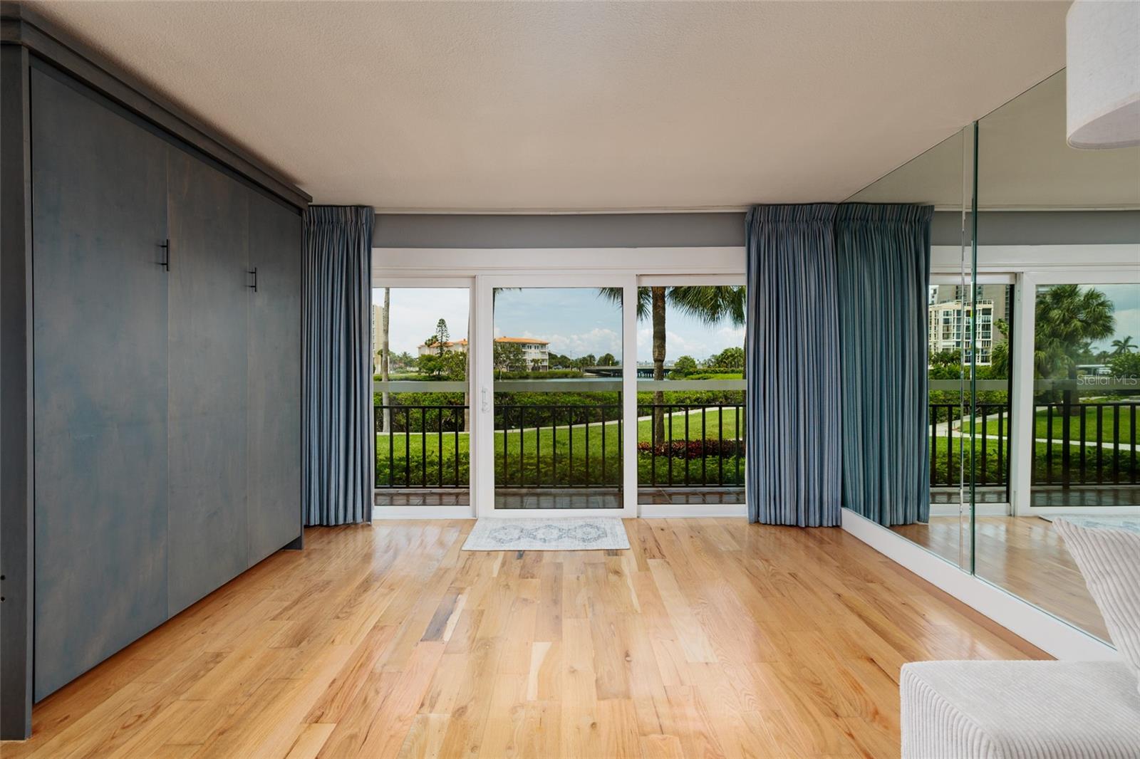 Extended living room area with Murphy bed, window treatment over the hurricane impact slider