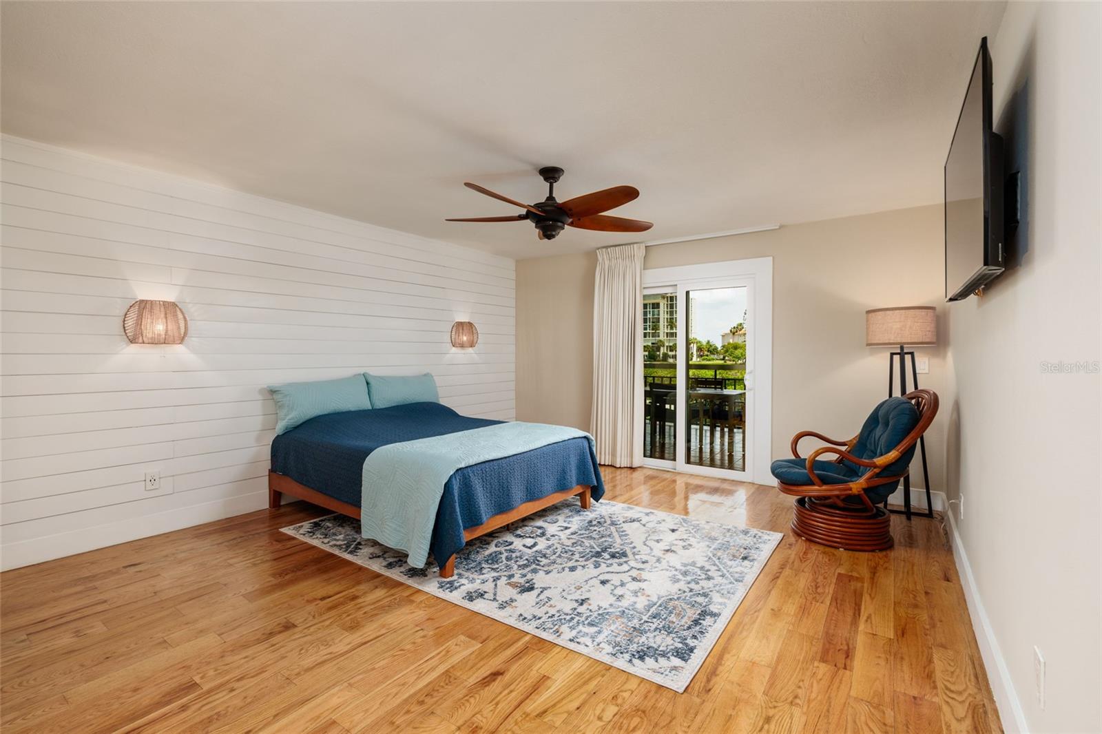 Large pimary bedroom with hurricane impact slider, wall mounted TV, plenty of room for king size bed, nightstands and full size dresser.  Engineered hardwood flooring.