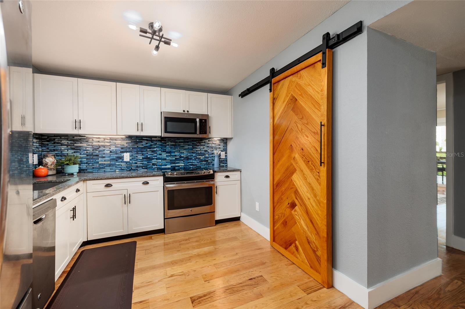 2nd kitchen view; notice the decorative barn door that slides open to the shelved pantry saving door congestion when working