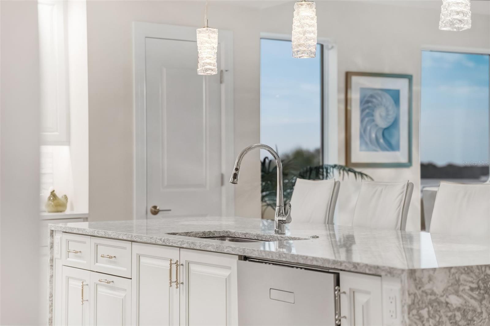 This is a look at the other side of the kitchen island with your sink & dishwasher plus lots of storage in your cabinets below.  Notice the crystal lights above the center island