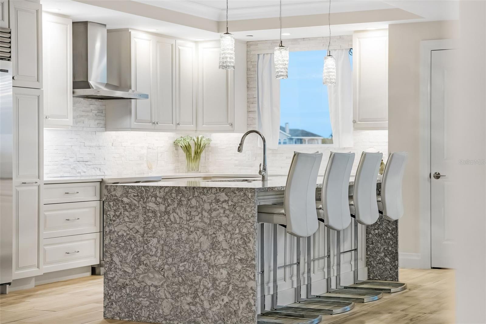 This shot shows you the natural light that the kitchen gets along with the under counter lighting.  Notice the waterfall finish for the center island that is reflected on both sides of the breakfast bar.
