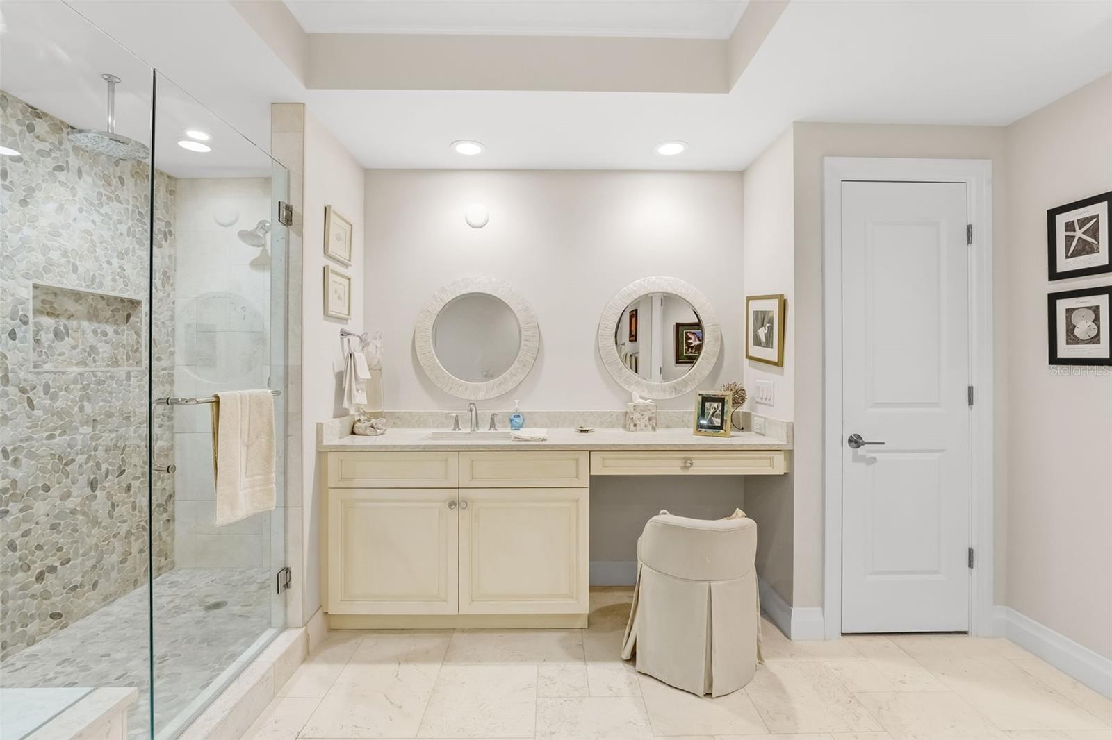 Separate vanities in the primary bathroom plus makeup area with a linen closet.