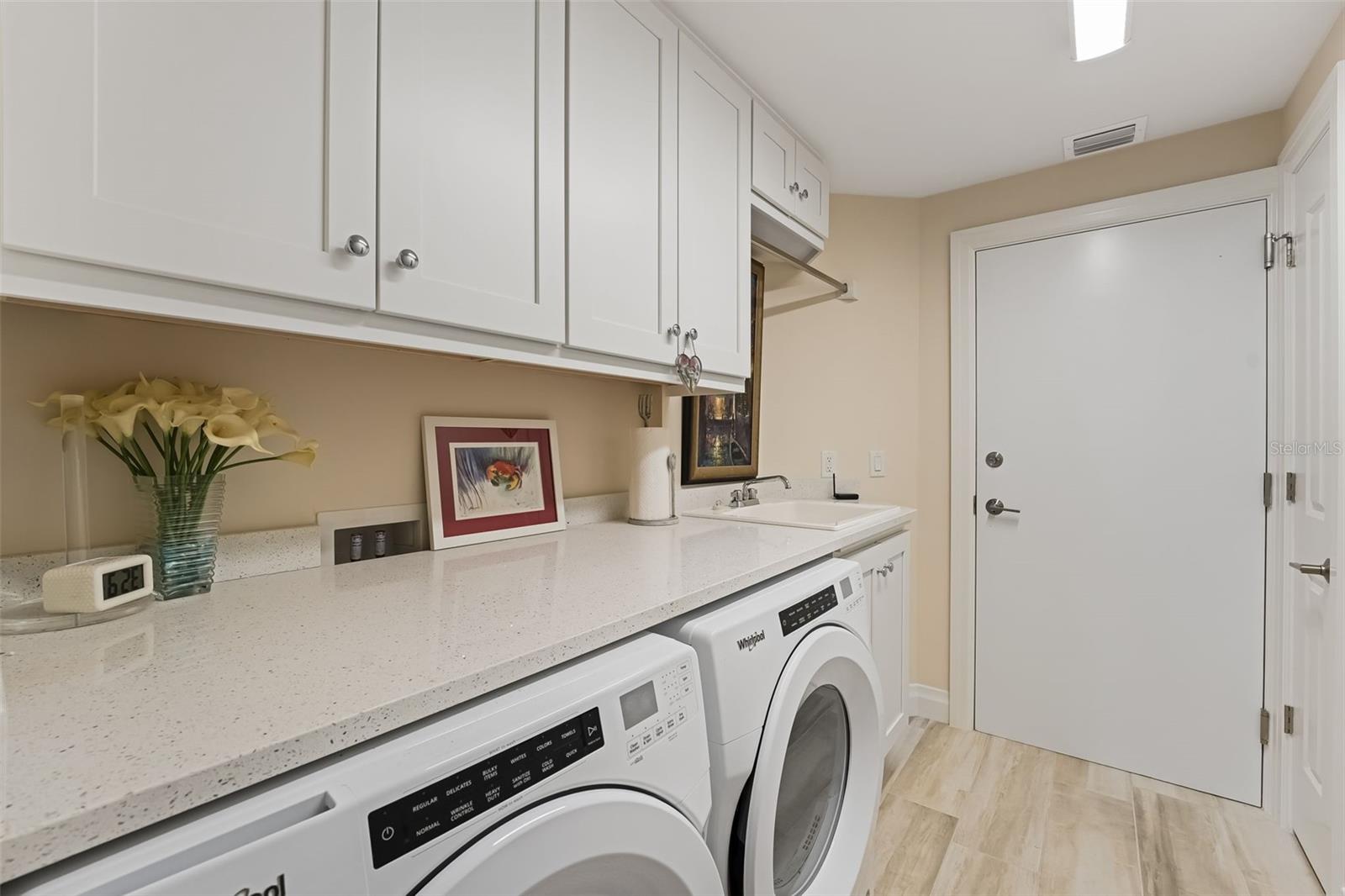 It is very nice to have a separate laundry room with storage, a sink and countertop space to fold the laundry.  Notice there is a 2nd door to leave the condo and use the stairs.  This door also leads to the trash shut for easy trash disposal.