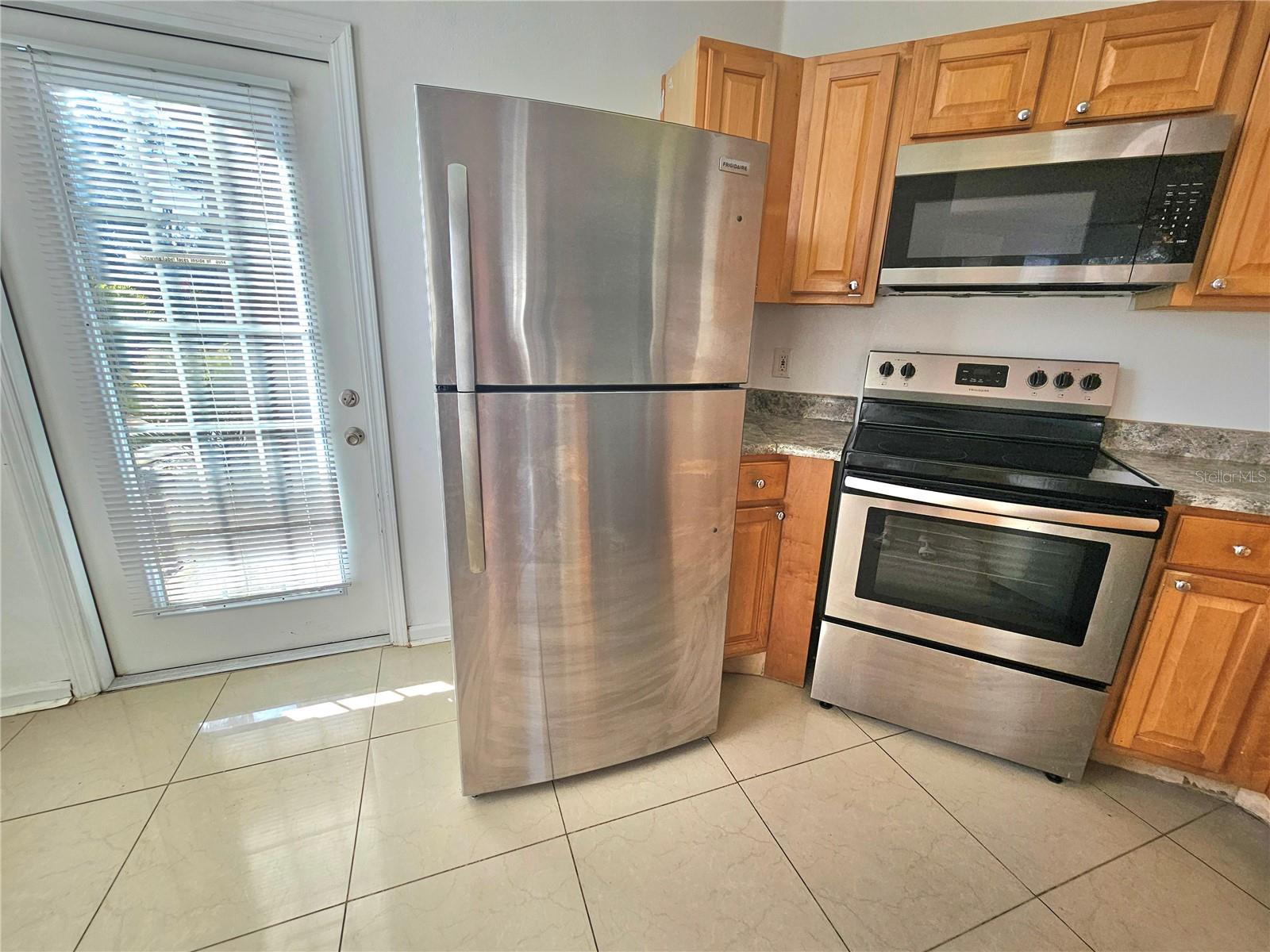 Kitchen side door, stainless steel appliances, refrigerator, stove, microwave