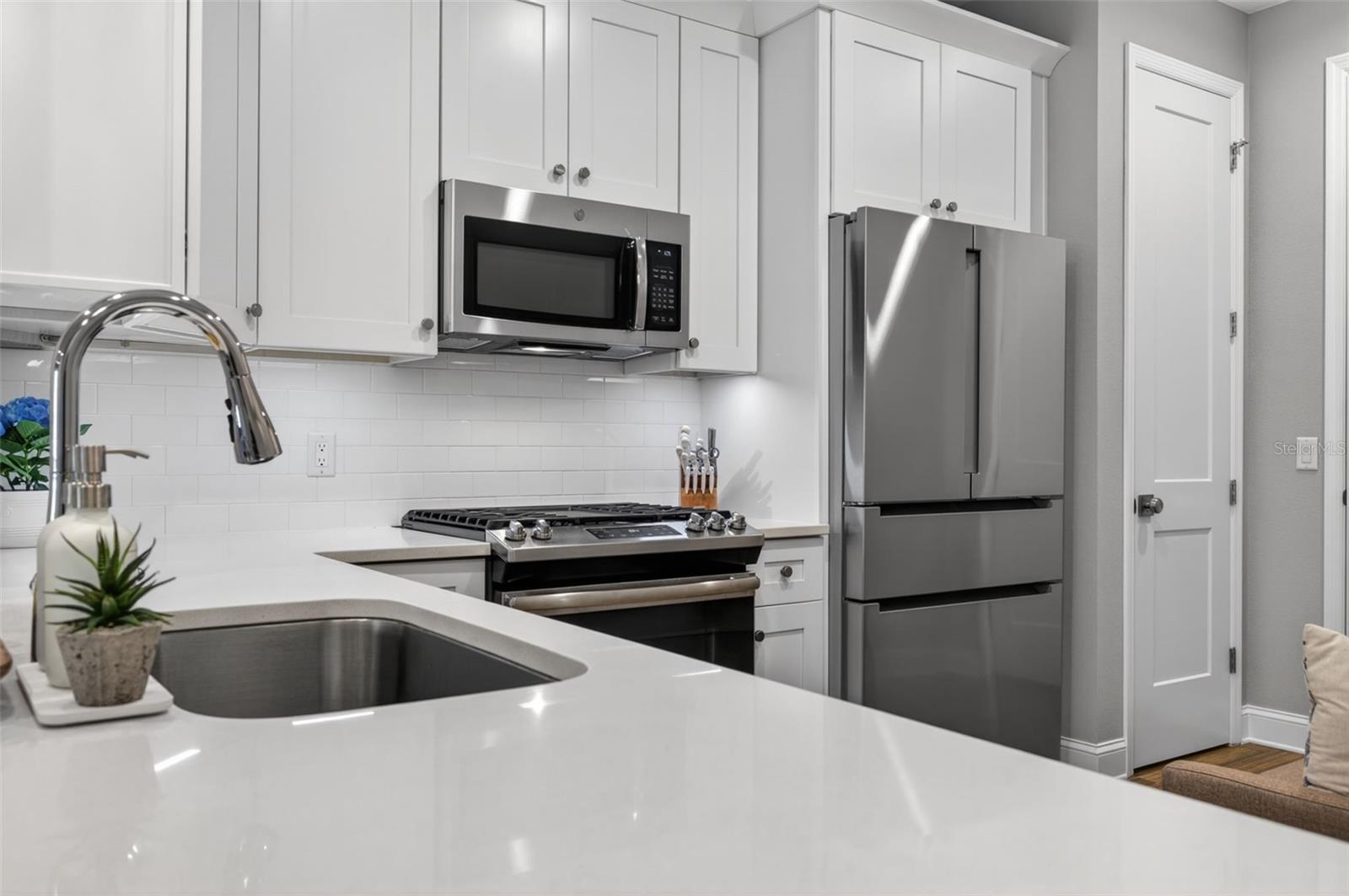 The kitchen has stone counters and all stainless steel appliances with gas 5 burner stove and center griddle and new Bosch refrigerator