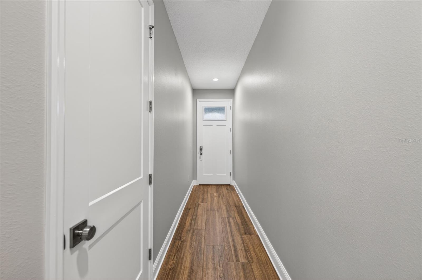 Long entry hallway with half bath on the left
