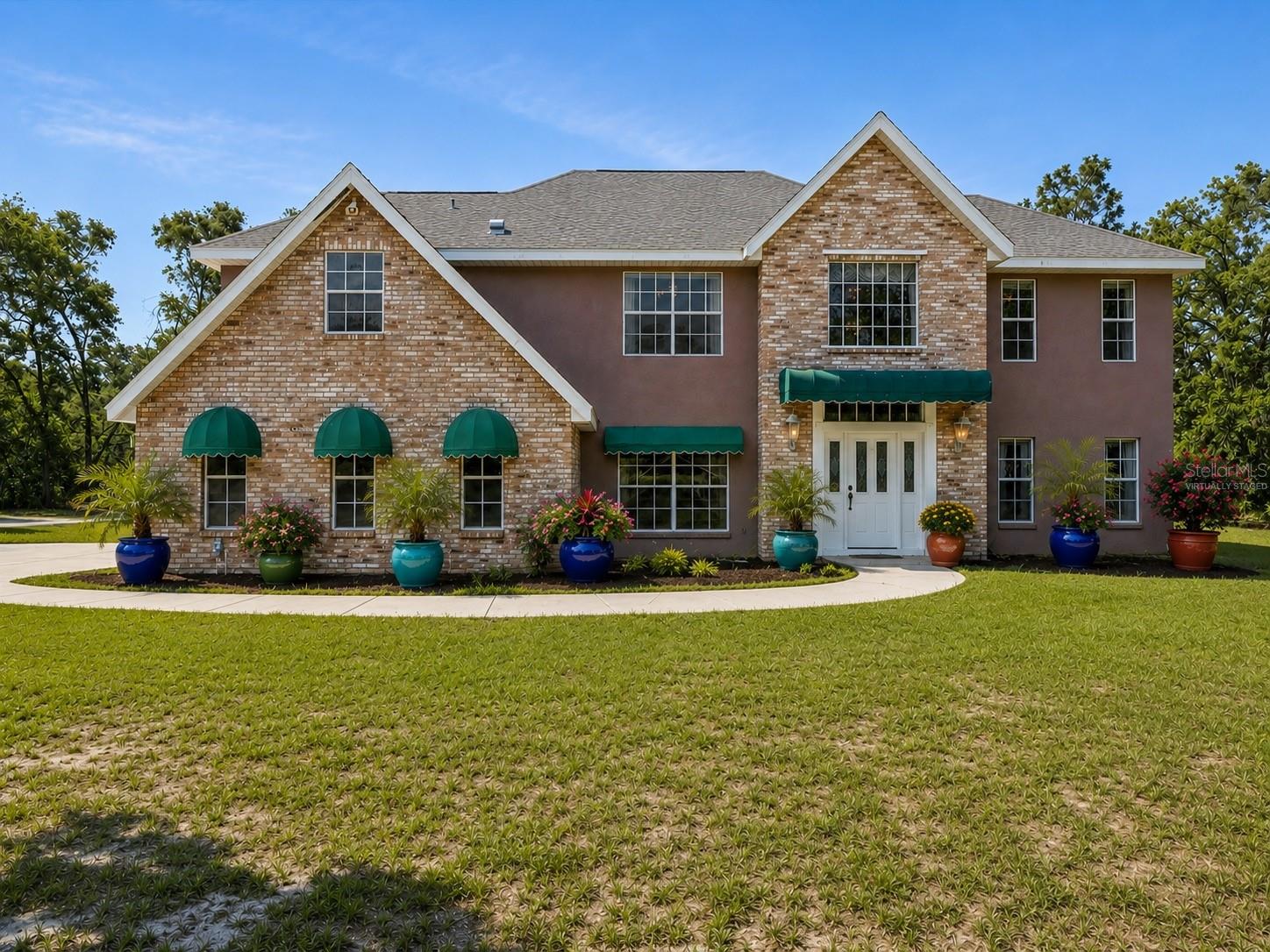 front virtually staged with potted plants and some mulch