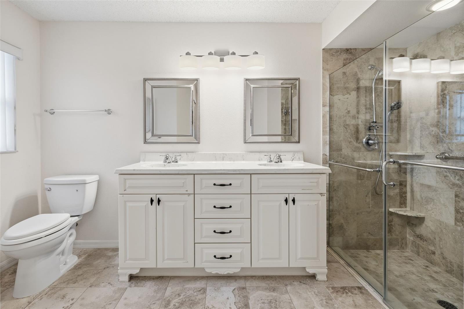 Updated Primary Bath with dual sink vanity and step-in shower.
