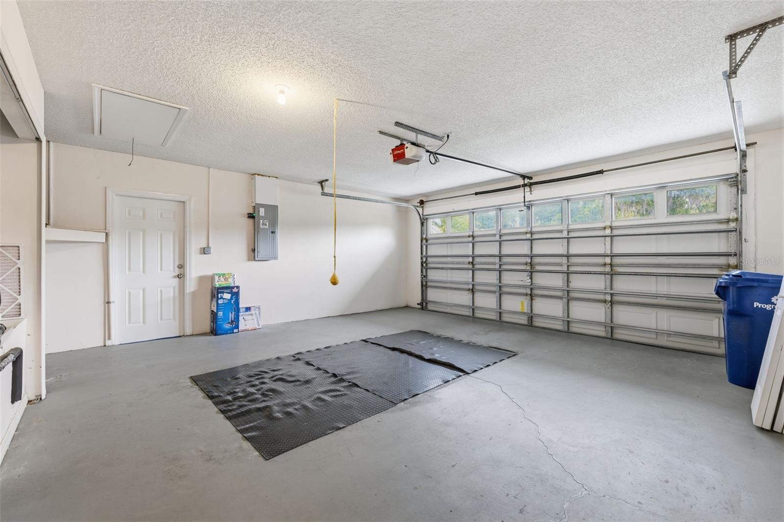 Clean two-car garage with side entry door from outside and automatic garage door opener. Surge protector on electrical panel.