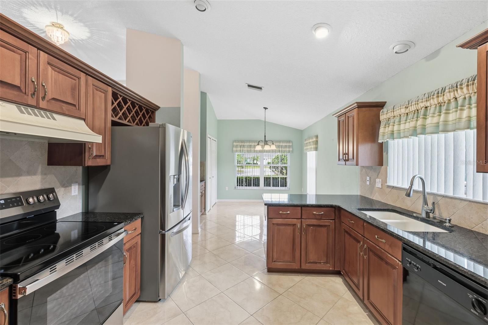 Kitchen with beautiful espresso cabinets, new SS refrigerator, granite counters.