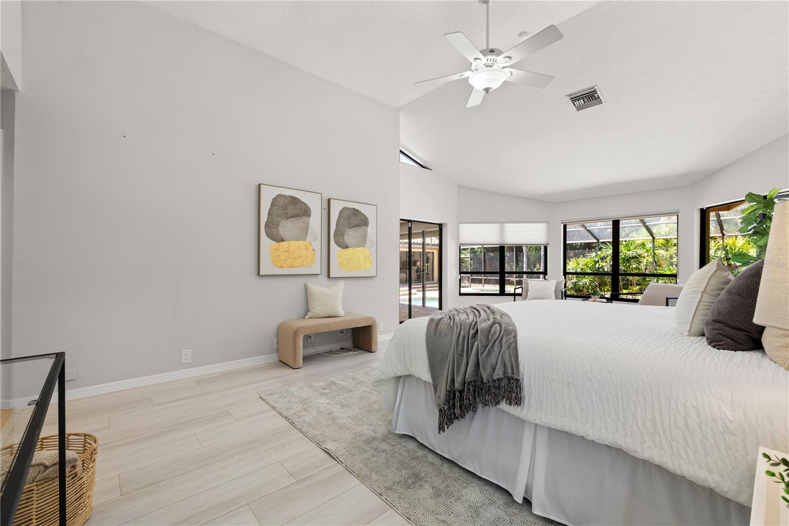 Large primary bedroom with sitting area and pool access