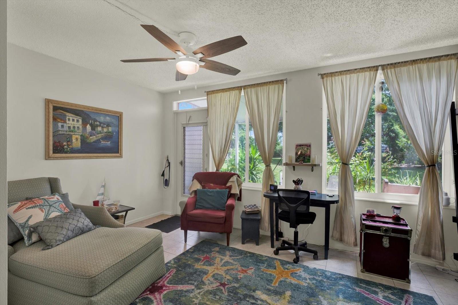Florida room/flex space with garden views and tile floors.