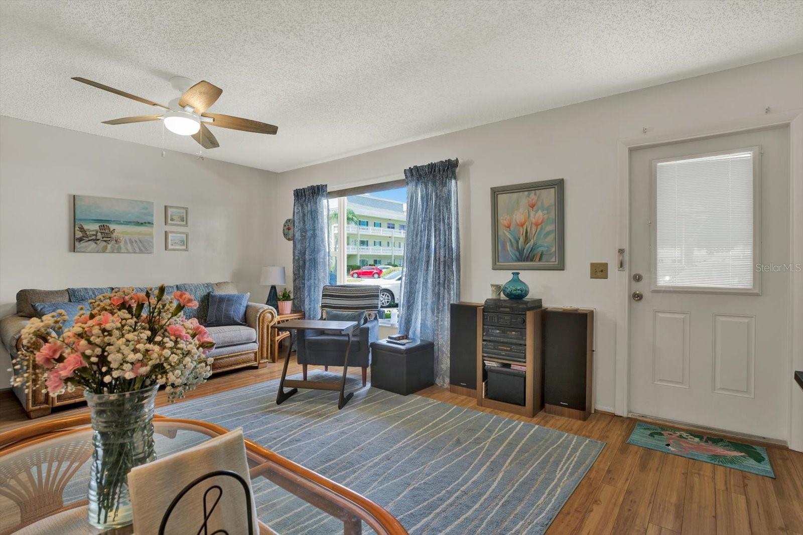 Spacious living room with natural light and ceiling fan
