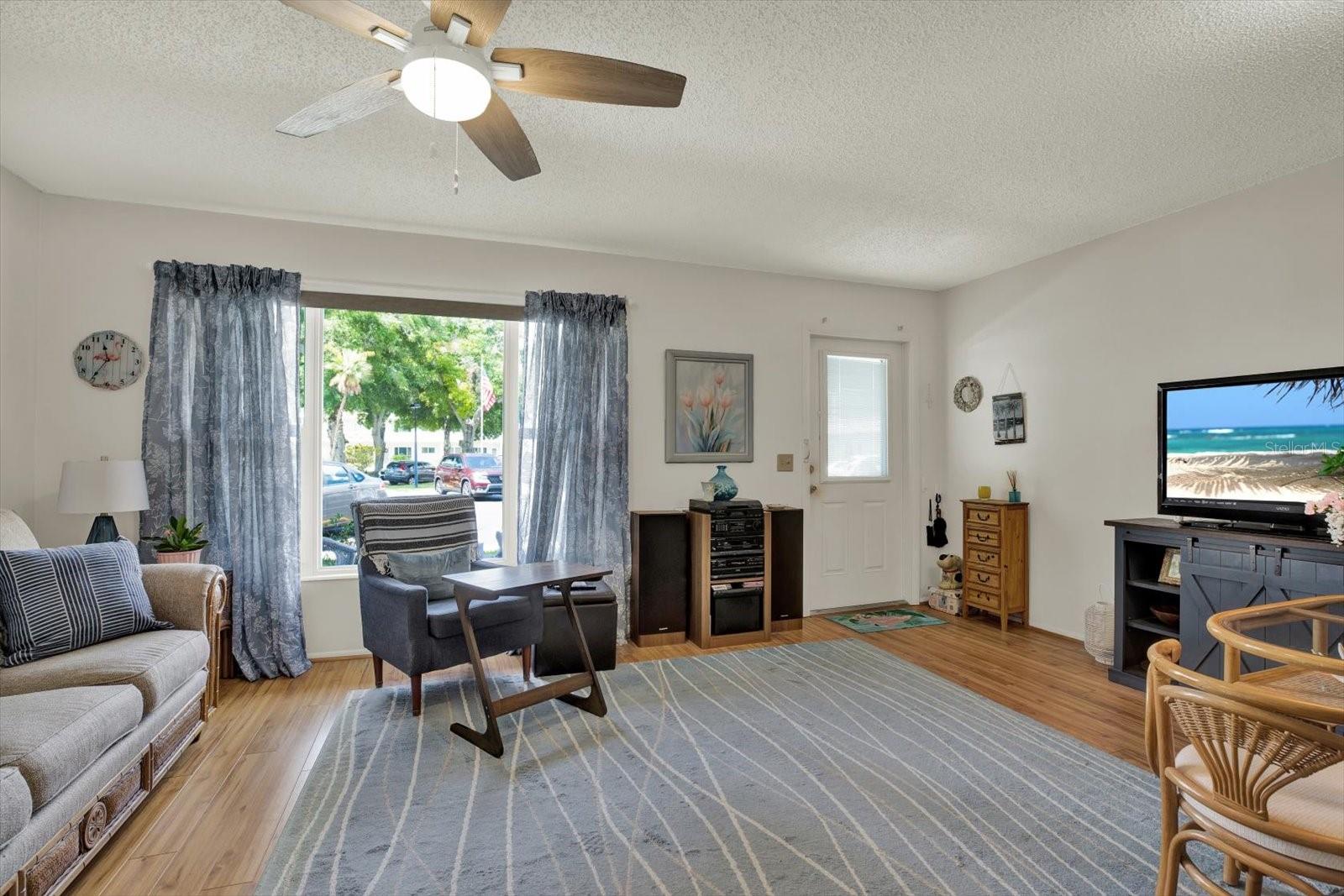 Living room with large window and wood-look vinyl floors