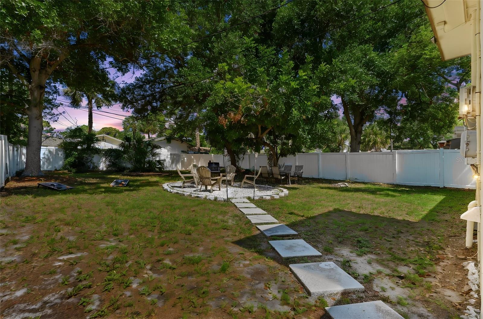 Huge spacious backyard with firepit area and shaded trees