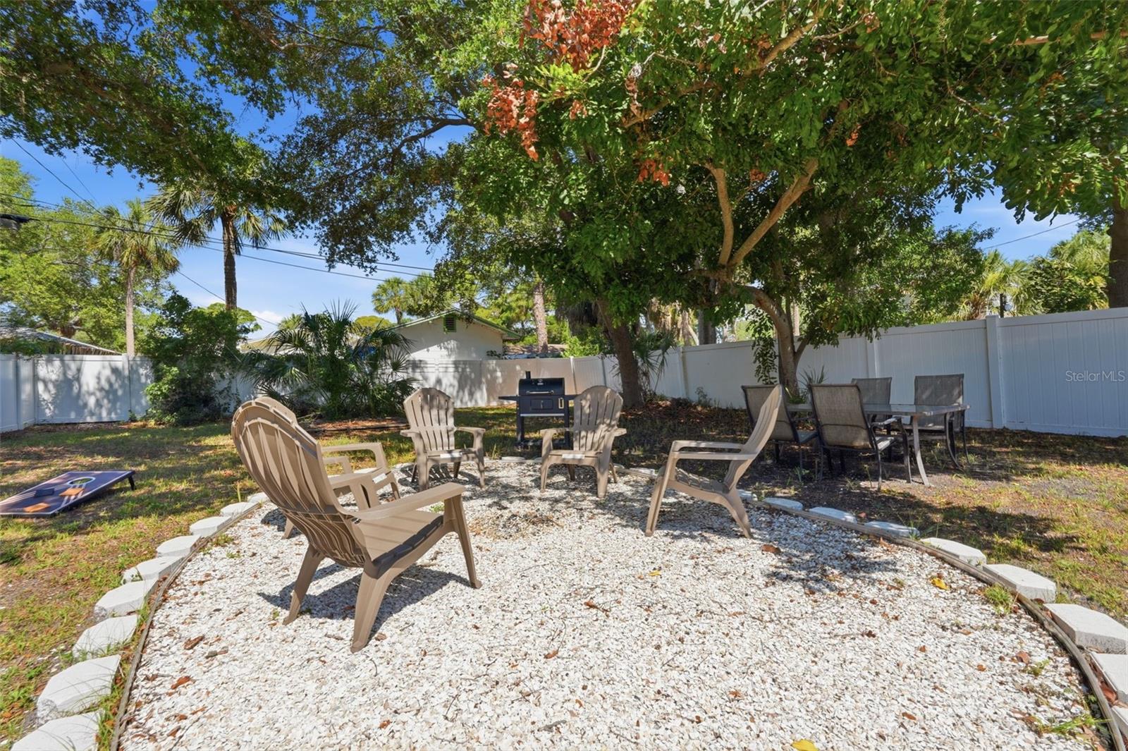 Huge spacious backyard with firepit area and shaded trees