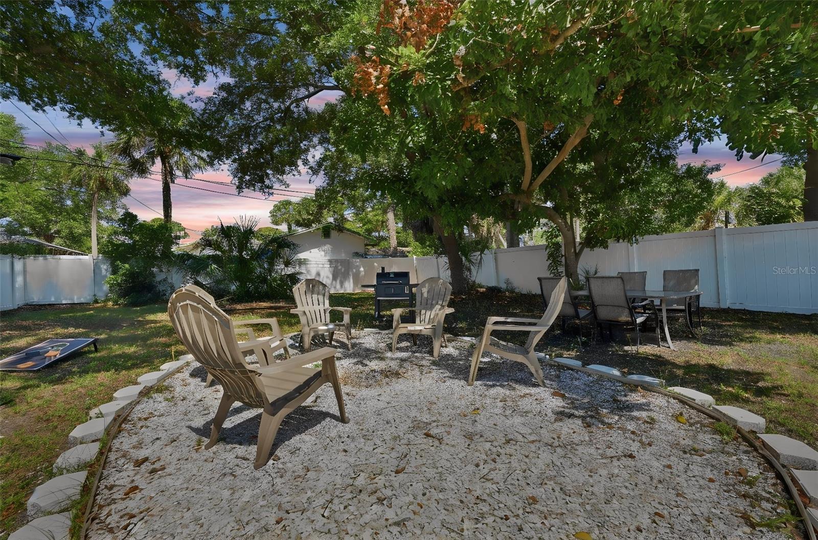 Huge spacious backyard with firepit area and shaded trees