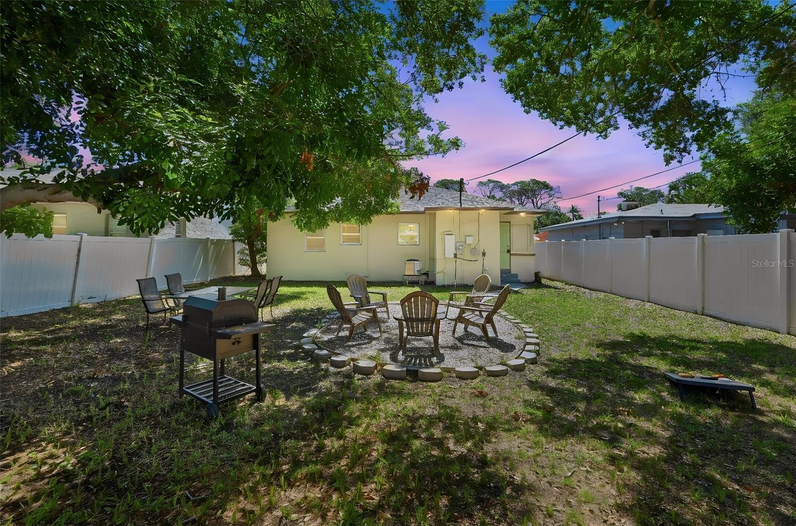 Huge spacious backyard with firepit area and shaded trees