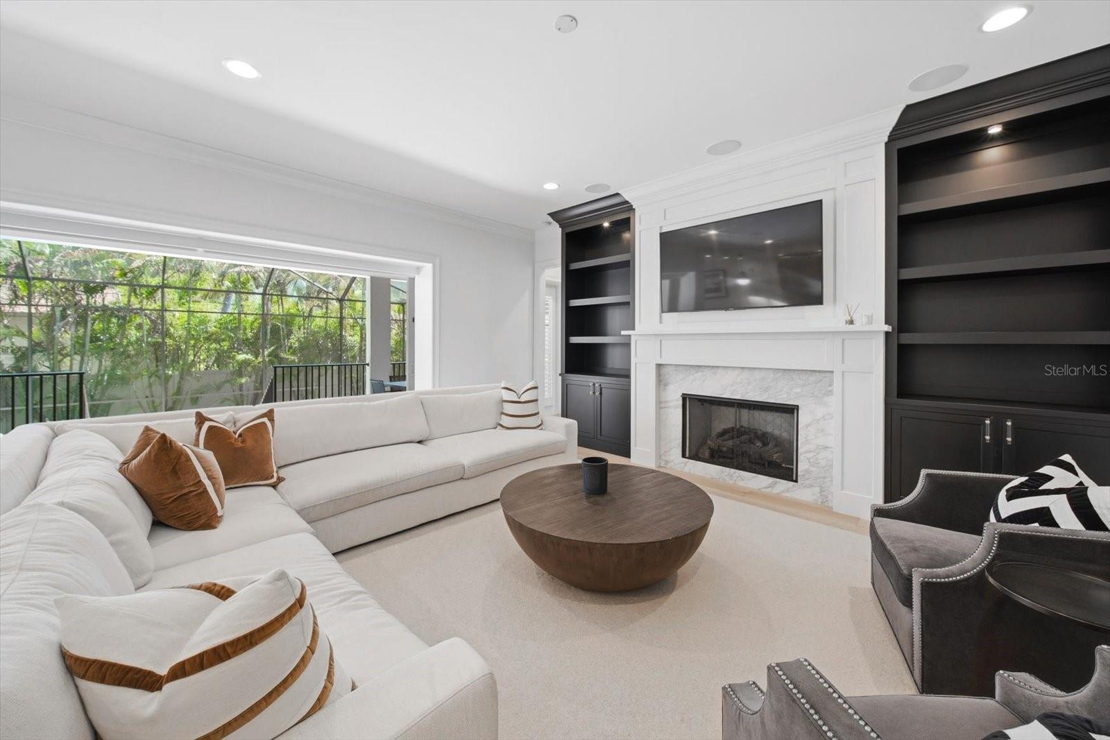 living room with built-ins and natural gas marble fireplace
