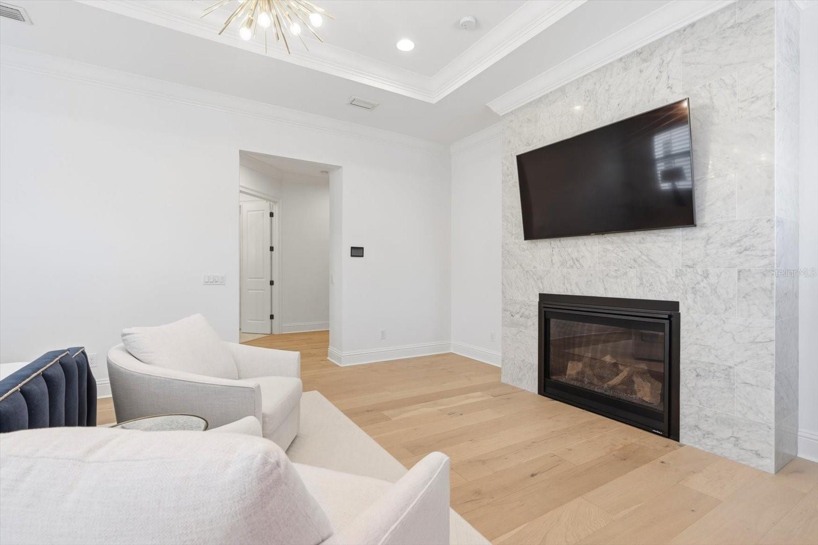 master sitting area with natural gas marble fireplace