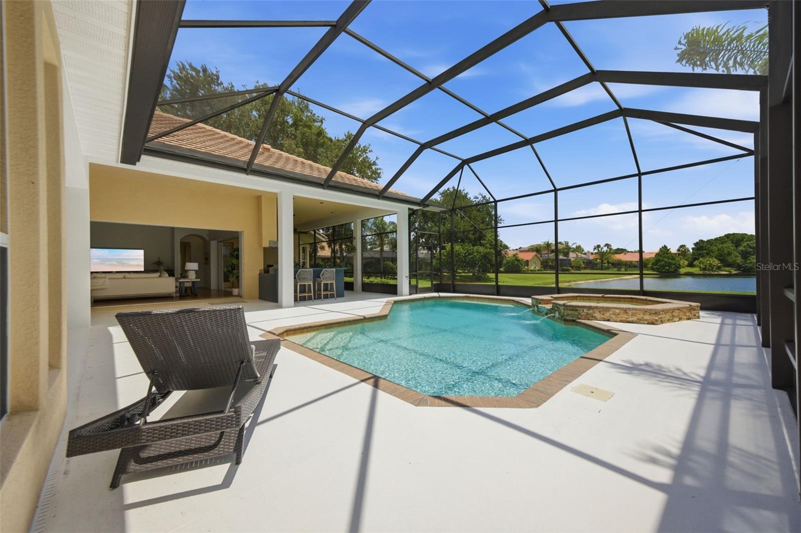 Spacious lanai with outdoor kitchen and pond view