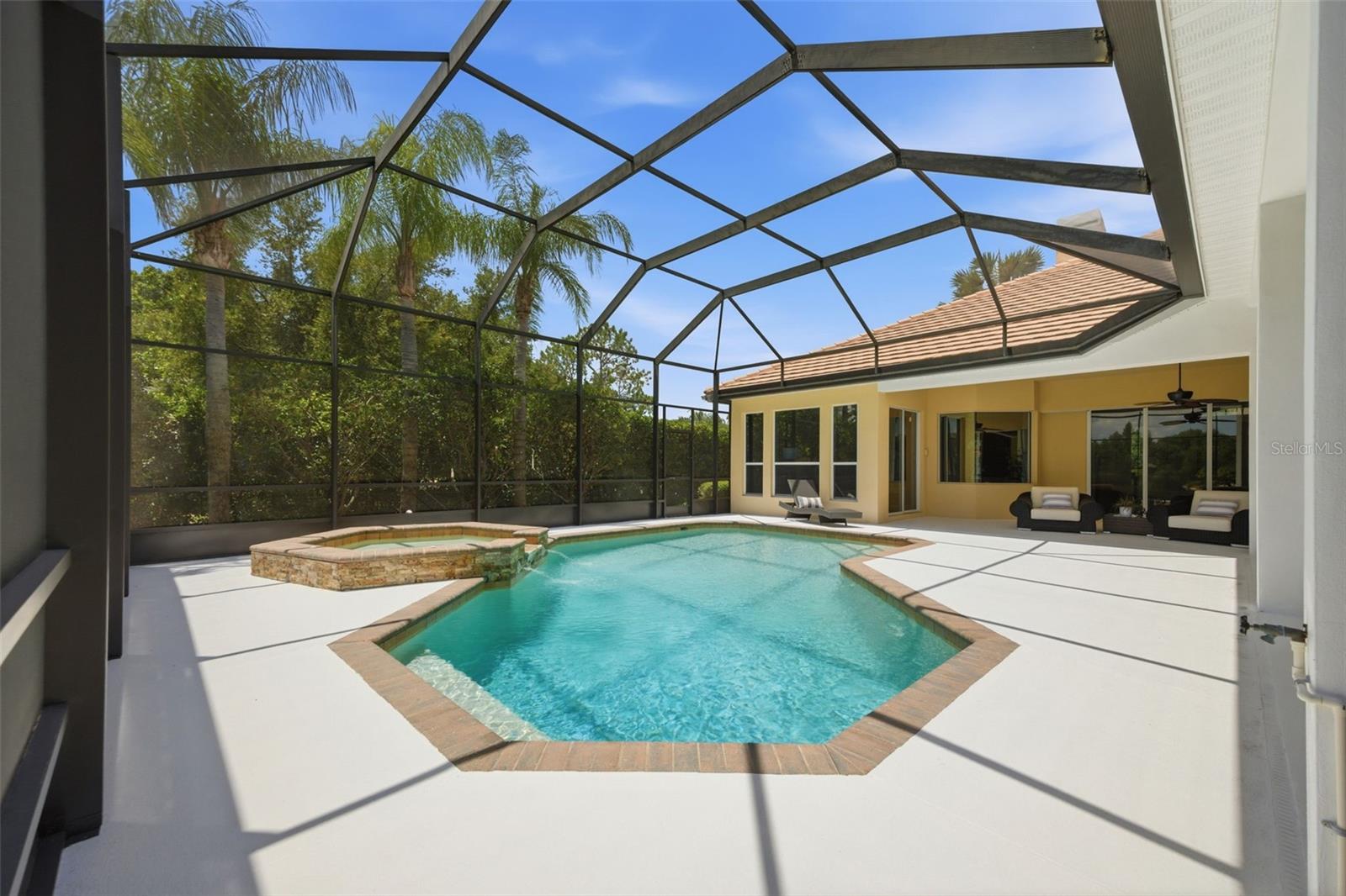 Spacious lanai with outdoor kitchen and pond view