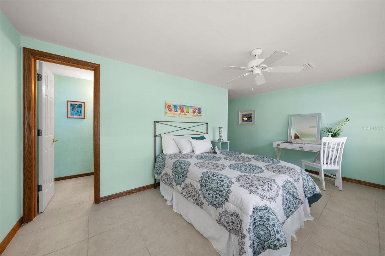 Guest bedroom number three located in the northeast corner of the home offers privacy and an ensuite bathroom, while overlooking the pool area.