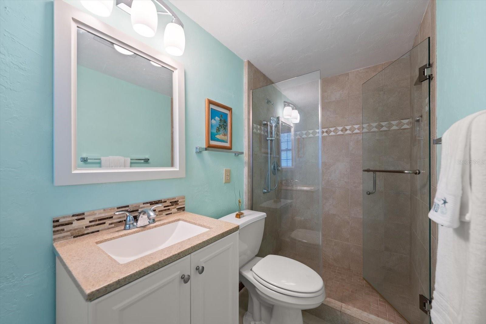Ensuite bathroom for bedroom number three offers a stylish walk-in shower with glass door.