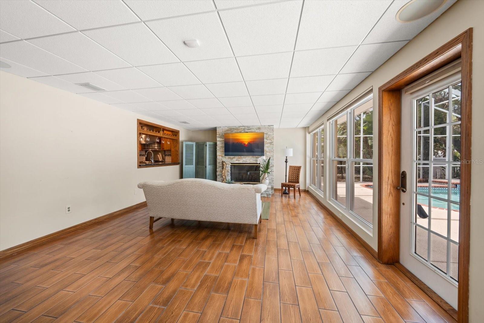 The great room offers the perfect transition from indoor to outdoor living, perfect for entertaining with a pass-through window to the kitchen and a wood-burning fireplace for cozy, intimate evenings.