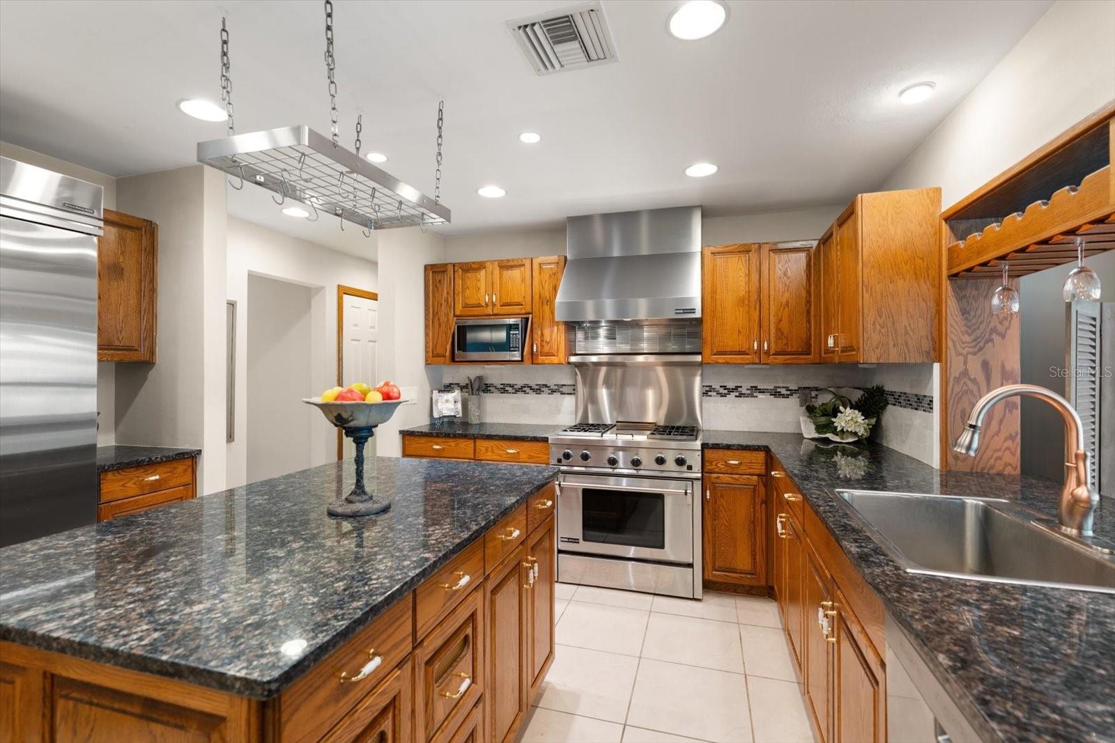 Attractive stainless steel appliances, stone counters, and adjustable lighting create the perfect cooking environment.