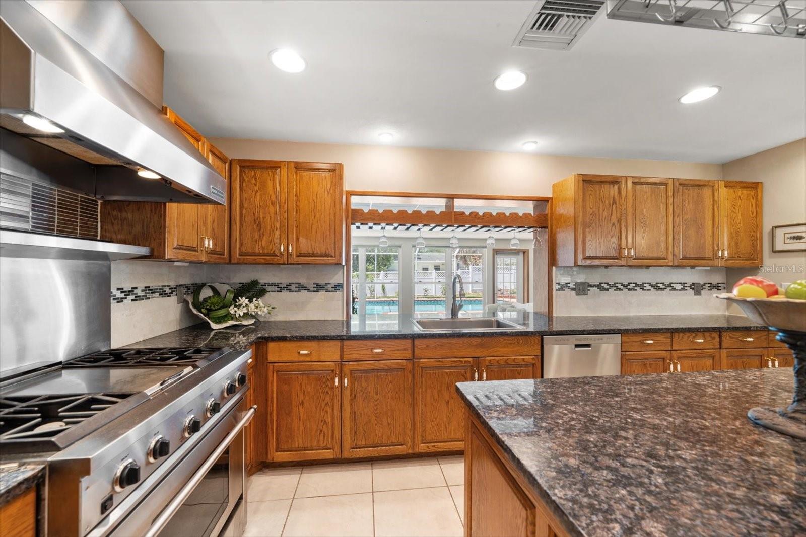 Cooking with a view of the great room and pool area from the grand kitchen area.