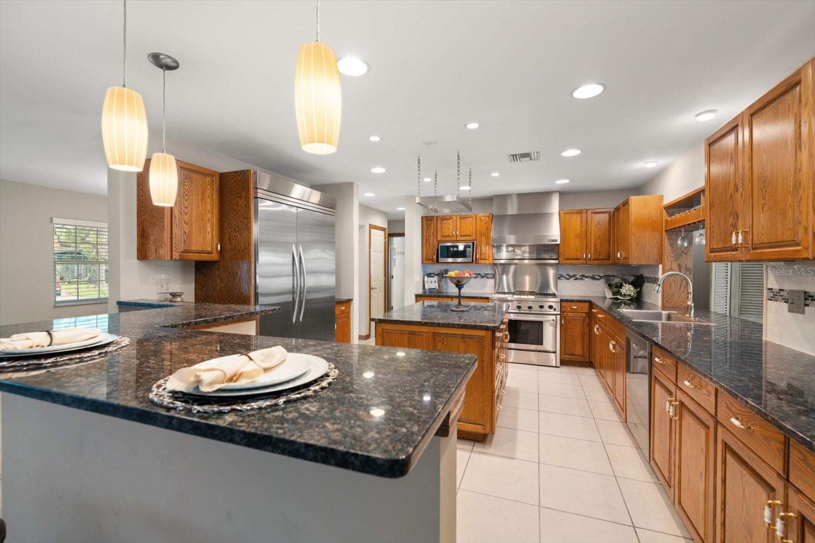 At the heart of the kitchen sits a dedicated center island, providing an independent workstation for meal prep, complete with overhead pot-rack potential and additional storage below.