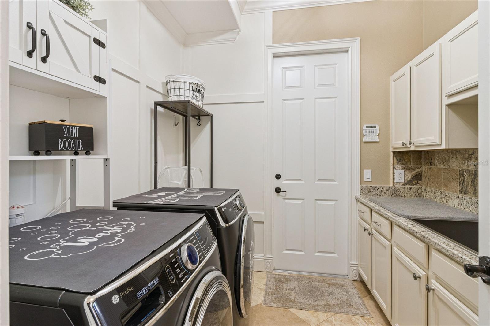 Expansive laundry with counter, cabinets, and deep basin sink.