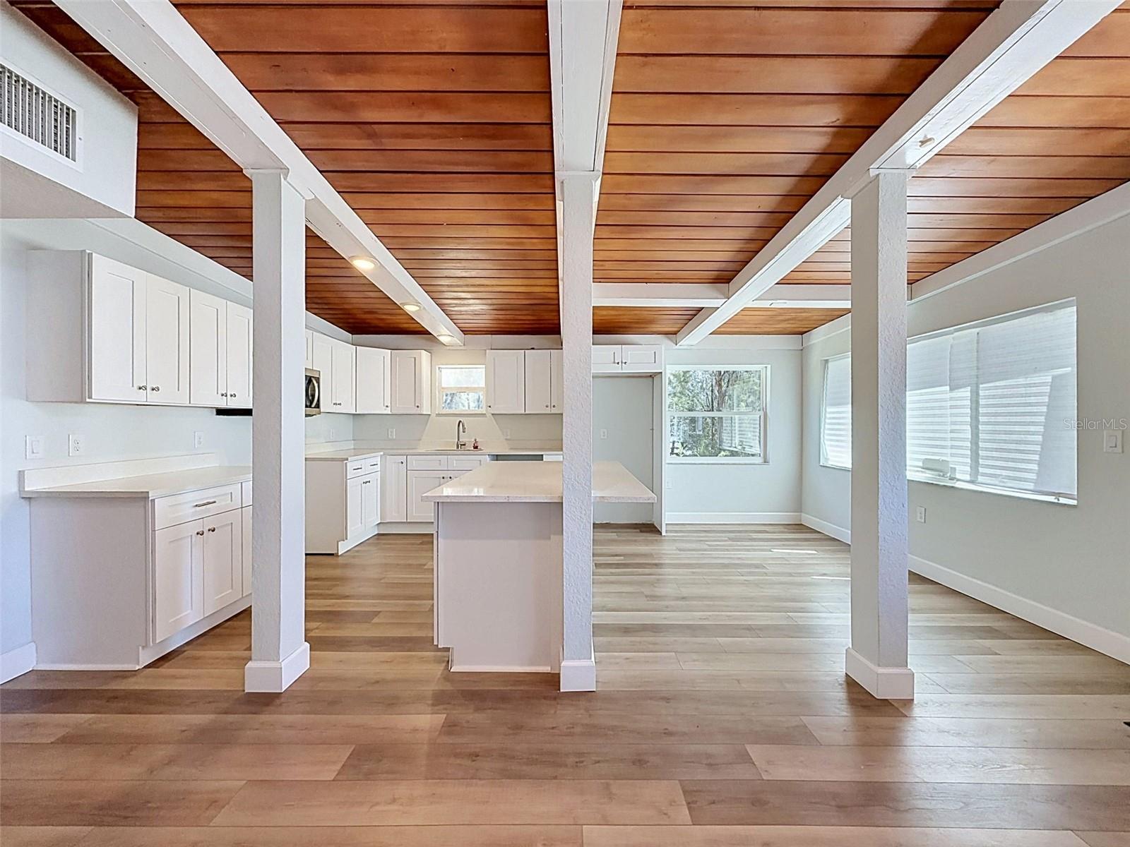 Warm tongue-and-groove wood ceilings add custom architectural character throughout the main living area.