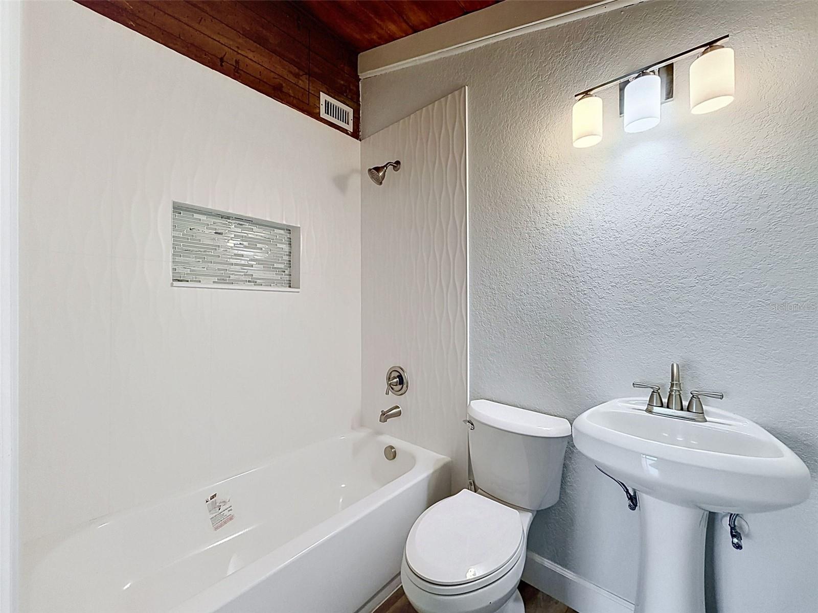 • Private primary bathroom featuring refreshed fixtures and decorative shower niche.