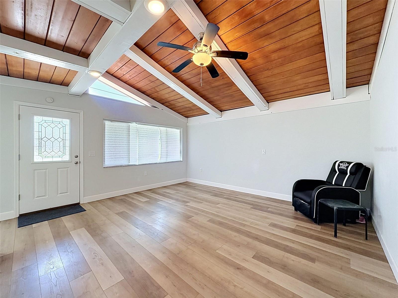 • Spacious living area featuring soaring vaulted wood ceilings and abundant natural light.