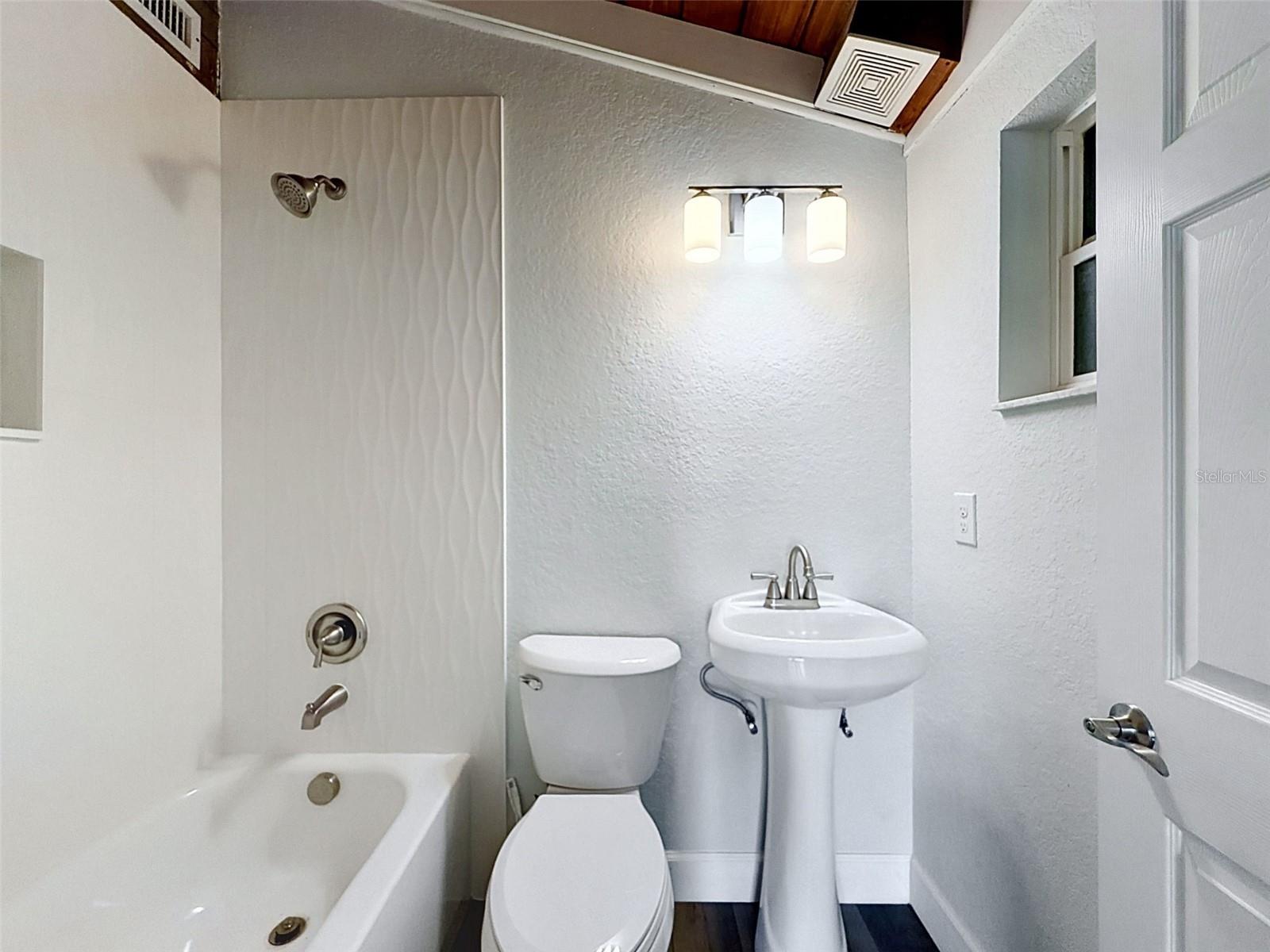 • Updated ensuite bathroom with modern tile finishes and clean coastal styling.