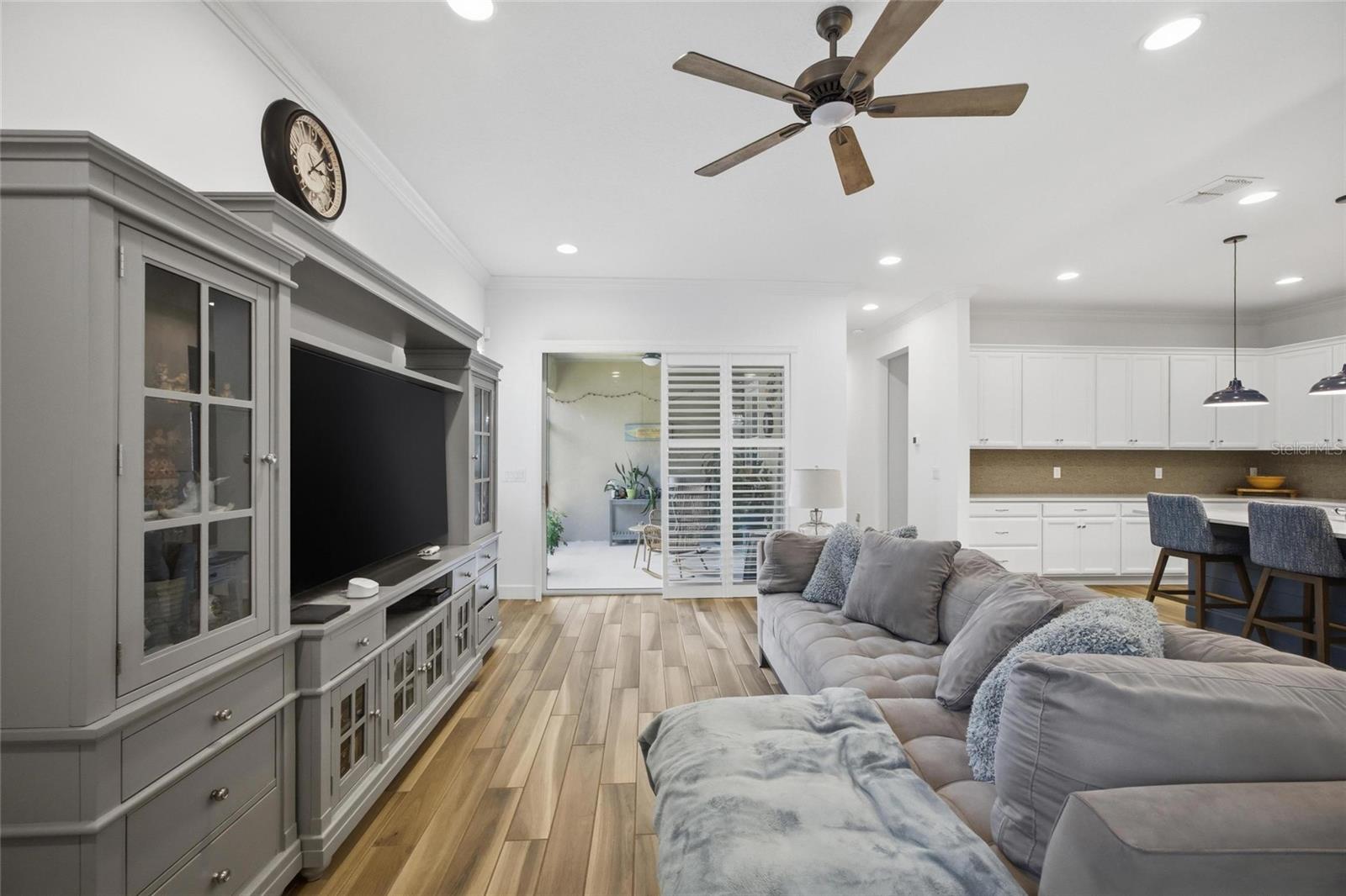 Sliding doors covered in Plantation Shutters leading to the screened lanai expands your open concept gathering space