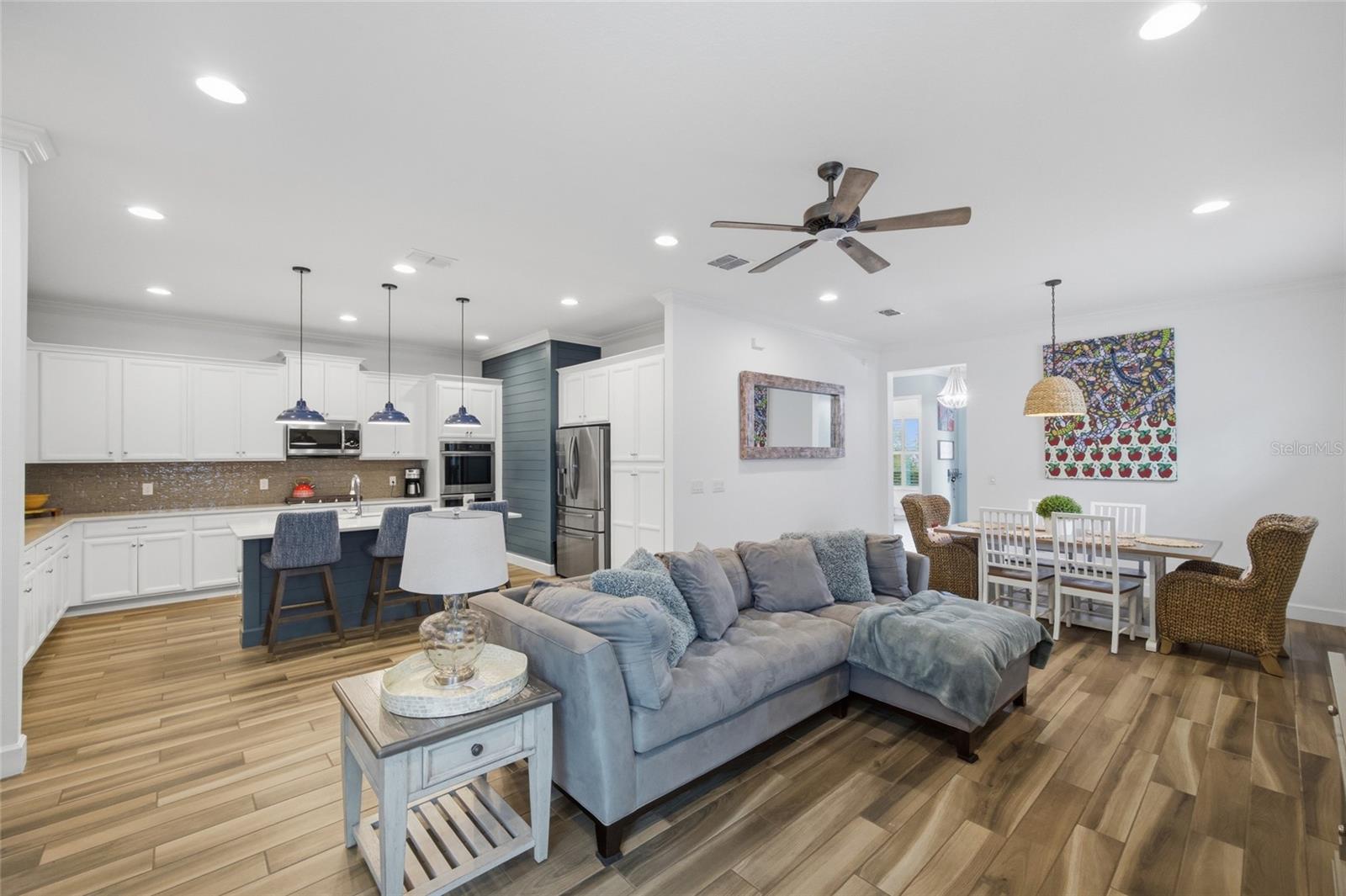 High ceilings, recessed lighting, custom light fixtures & ceiling fan enhance the kitchen, living, dining open space