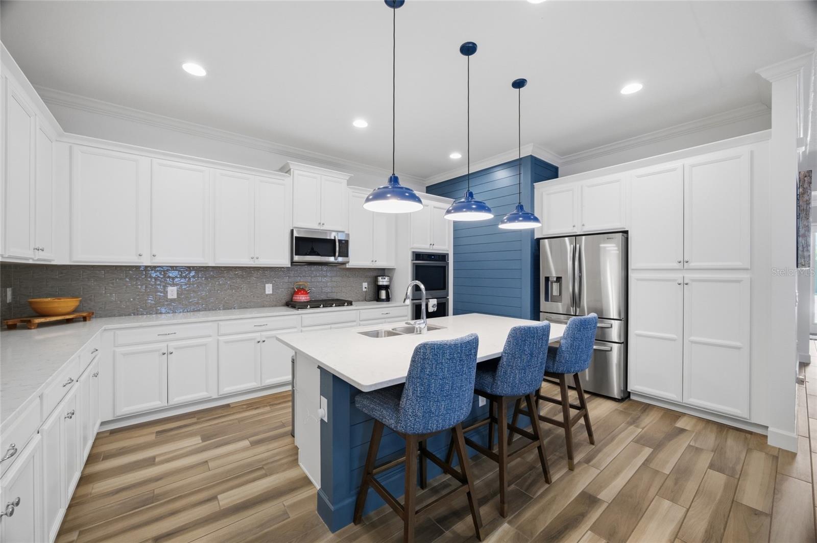 Refrigerator with filtered water, ice maker & large bottom freezer next to your pantry cabinets complete the space.