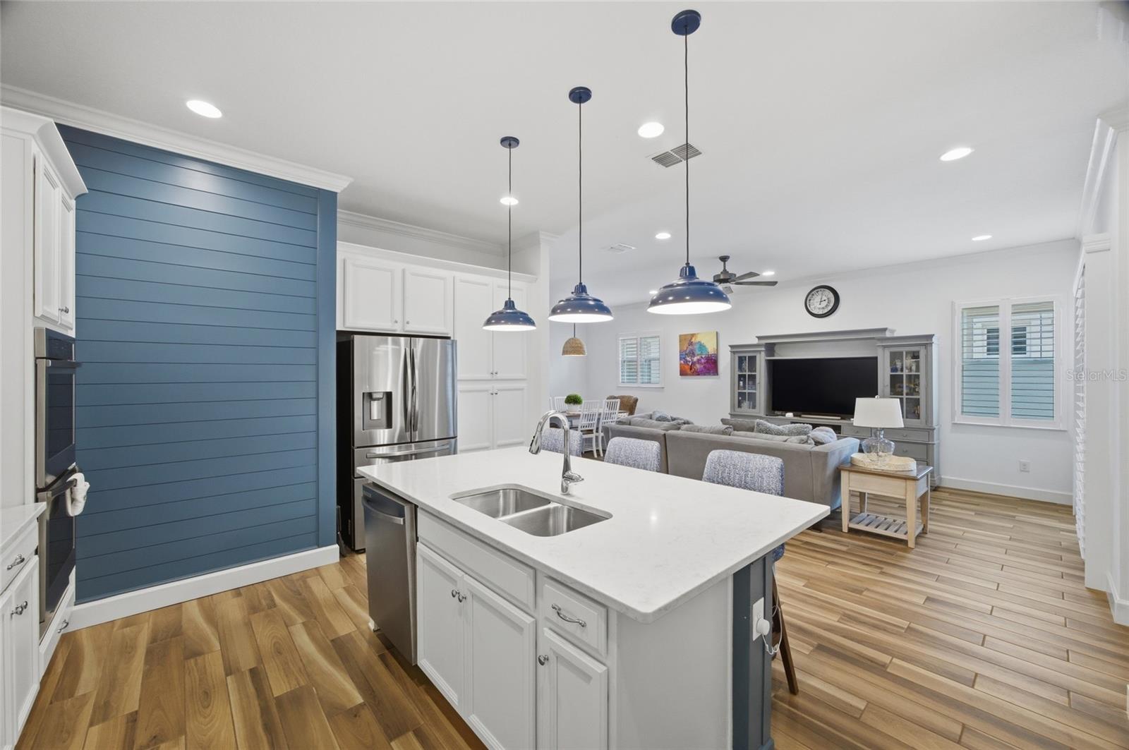 Quartz counters, dual stainless sink, storage & dishwasher complete this large breakfast bar