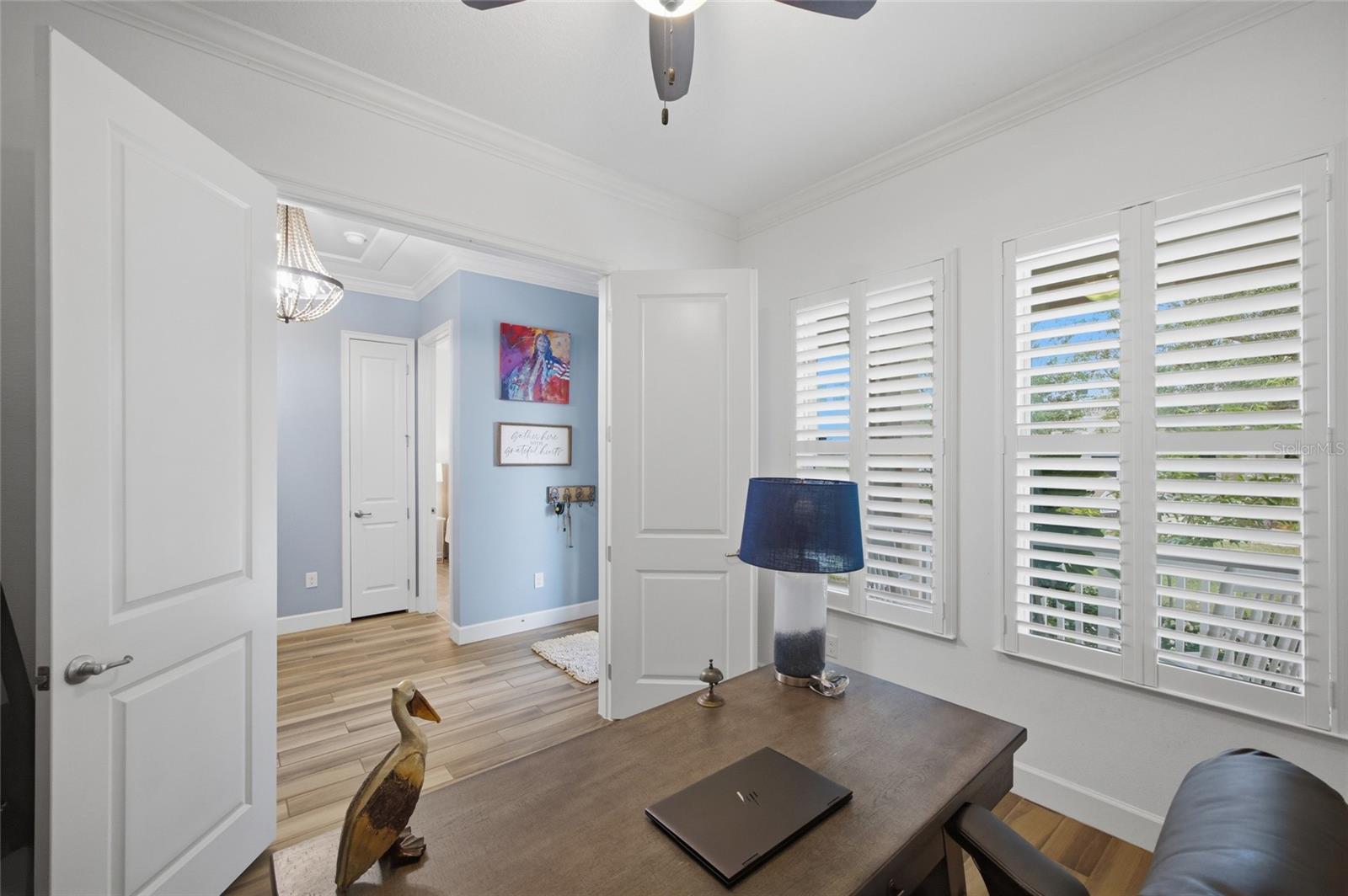 Den / Office with double doors, plantation shutters, ceiling fan & great natural window light at the front of the house.
