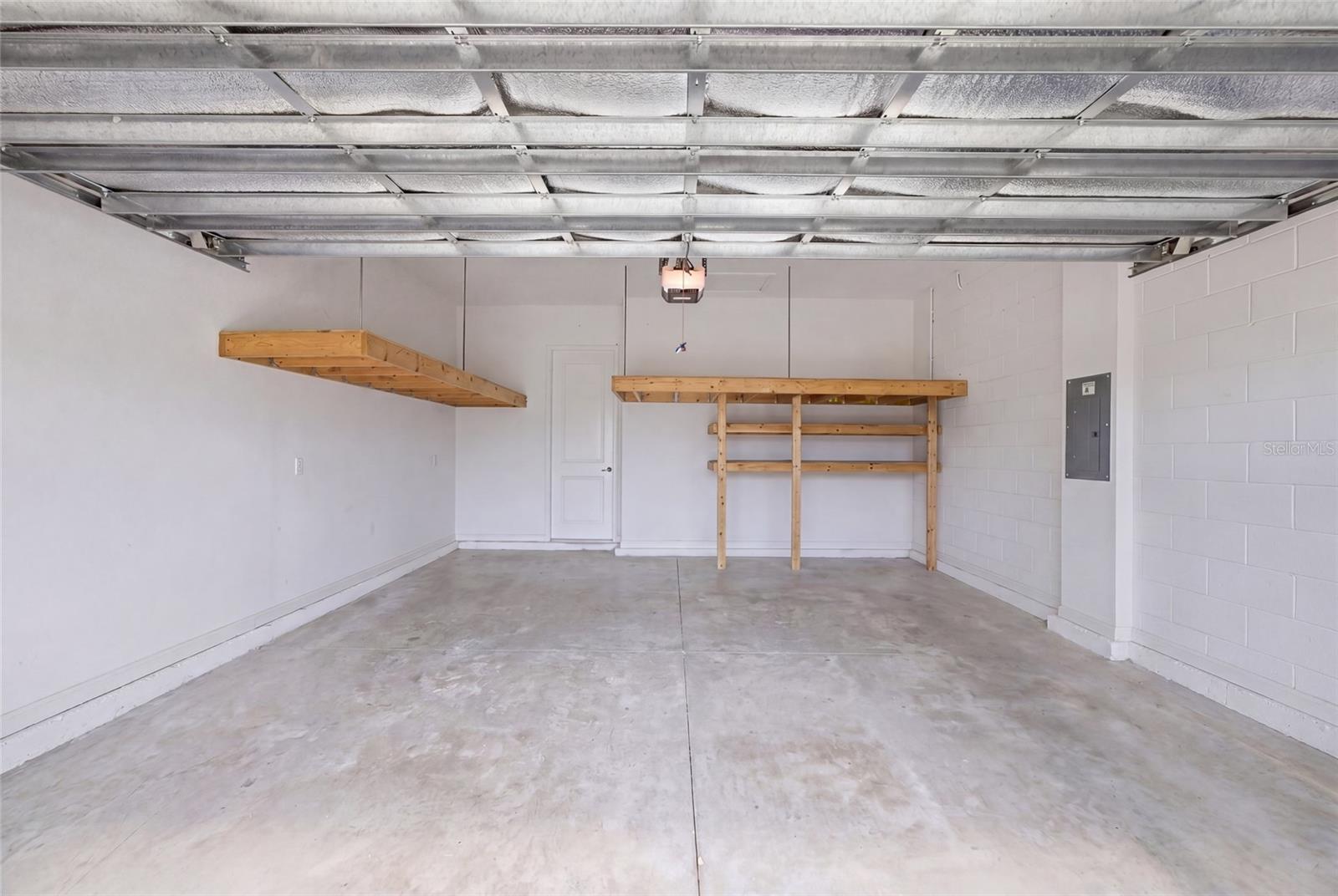 Garage with CUSTOM WOOD storage racks and insulated garage door.