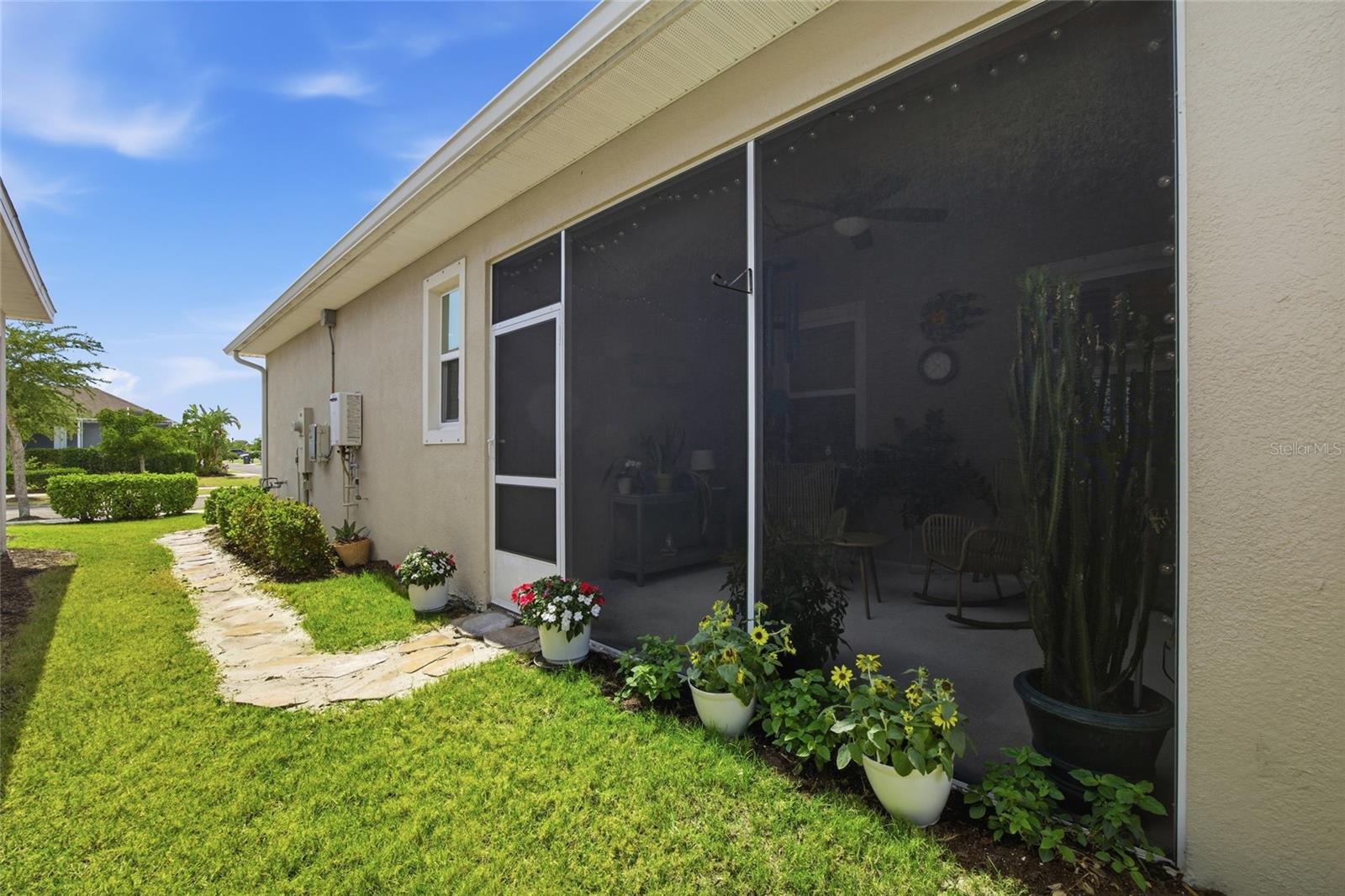 Screened lanai with stone paver walkway to driveway.